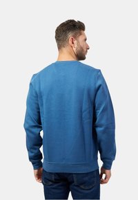 Felpa blu in misto cotone, con collo rotondo e polsini a costine. Tessuto morbido con vestibilità comoda e dettaglio posteriore.