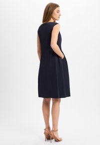 Navy ärmelloses Kleid mit geradem Schnitt, runder Halslinie und seitlichen Taschen; glattes Material und knielanges Design.
