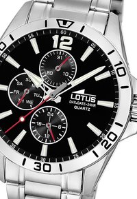 Montre en acier inoxydable argenté avec un cadran noir. Ses caractéristiques incluent des sous-cadrans pour la date, le jour et 24 heures, des index lumineux et des accents rouges.