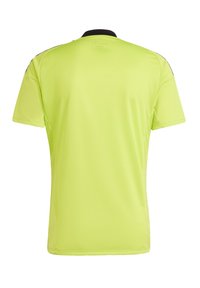 Camisa deportiva fluorescente amarilla con cuello negro. Mangas cortas, tela texturizada y diseño sin costuras. Sin logotipos ni patrones visibles.