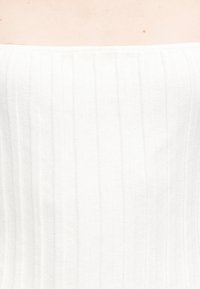 Λευκό τοπ χωρίς τιράντες από υφασμάτινη υφή με κάθετα ριγέ μοτίβα, με ομαλή επιφάνεια και εφαρμοστή γραμμή.