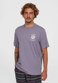 Lavendel T-shirt met korte mouwen van katoen, met een ronde witte zonafbeelding op de linkerborst. Crew neck ontwerp, ontspannen pasvorm.