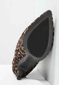 Scarpa con tacco alto in stampa leopardata, con tomaia in tessuto texturizzato, punta affusolata e suola nera liscia. Presenta un design di tacco snodato.