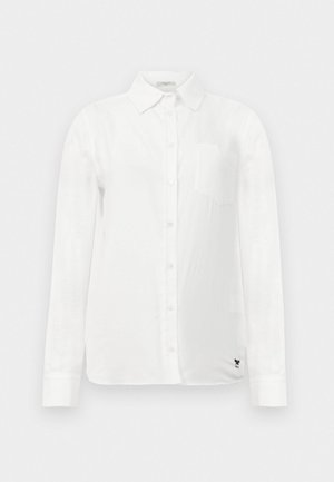 White long-sleeve shirt with a button-down collar, a single chest pocket, and subtle textured fabric. Features black embroidered logo detail.