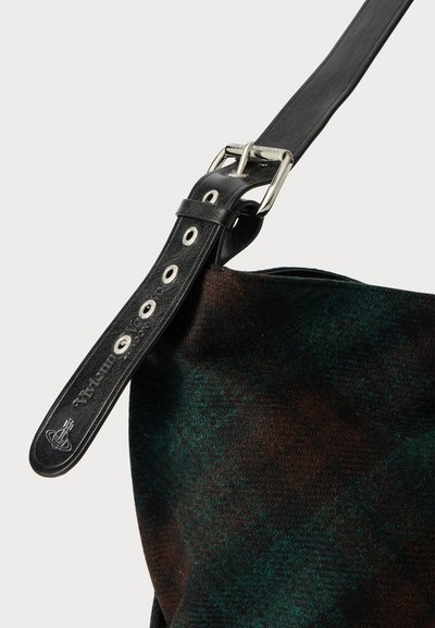 Villa ja nahkakoti, jossa on musta nahkahihna hopeaosilla, tumma vihreä ja ruskea houndstooth-kuvio sekä pehmeä tekstuuri.