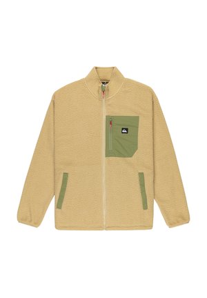 Beige fleece jacket with a high collar, front zipper, and green chest pocket. Features side pockets and a textured, soft finish.