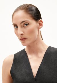 Dunkelgraues ärmelloses Kleid mit tiefem V-Ausschnitt, aus strukturiertem Stoff gefertigt, mit schmeichelhaftem Schnitt und glattem, sauberem Finish.