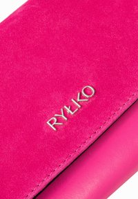 Portafoglio in suede rosa con logo in argento "RYŁKO." Presenta dettagli in pelle liscia a contrasto e cuciture visibili.