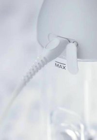 Witte elektrische waterkoker tuit met een knop voor het uitschenken, voorzien van een gestructureerde siliconen grip en een duidelijke waterniveau-indicator met het label "MAX."