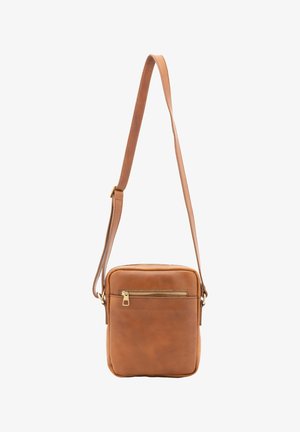 Bruine leren crossbodytas met verstelbare riem en voorvak met ritssluiting op een witte achtergrond.