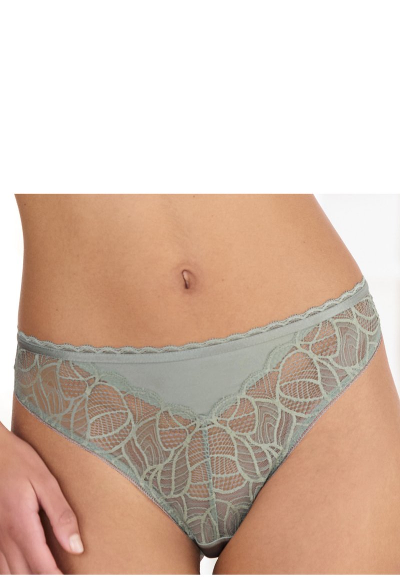 Hellgrüne Spitzenunterhose mit floralem Design, featuring gezackte Kanten und transparente Einsätze, die die filigrane Spitzenstruktur und Details hervorheben.