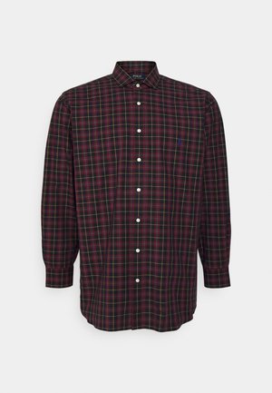 Chemise à manches longues avec boutons, motif à carreaux noir, rouge et jaune, col classique et petit logo brodé sur la poitrine gauche.