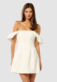 Vestido blanco de tirantes caídos con mangas abullonadas, corsé ajustado y falda acampanada. Textura suave con pliegues y un diseño minimalista.