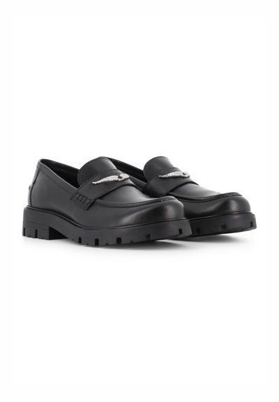 Μαύρα δερμάτινα loafers με χοντρές σόλες και ασημένιες μεταλλικές λεπτομέρειες σε σχήμα φτερών στα λουράκια, εμφανιζόμενα σε λευκό φόντο.