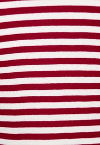 Tessuto a righe rosse e bianche con linee orizzontali uniformi, realizzato in un materiale morbido e lavorato a maglia con una superficie liscia.
