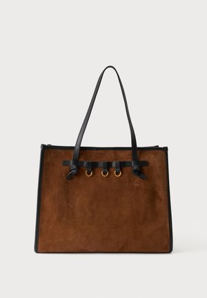 Borsa a mano in pelle scamosciata marrone con manici e rifiniture in pelle nera, con tre anelli dorati e dettagli in cinturino di pelle sul davanti.