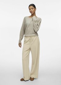 Beige gebreid sweater met een brede decolleté, gecombineerd met crèmekleurige wijde broek met een elastische tailleband en voornaaddetails. Tan schoenen maken de outfit compleet.