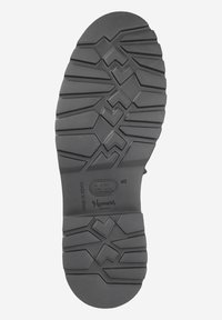 Black rubber shoe sole featuring a patterned tread design with zigzag and triangle shapes. Markings include size 40 and "Homers, MADE IN SPAIN."