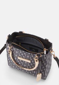 Šedá vzorovaná kabelka s kovovými prvky ve zlaté barvě, dvojitými horními uchy a vnitřními zipovými kapsami. Exteriér z texturované látky.