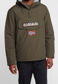 Oliwkowa bluza z kapturem, z zamkiem z przodu, dużą kieszenią na piersi i naszywką z flagą Norwegii. Posiada podszycie dla większego ciepła.