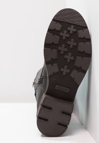 Sorte læder ankelstøvler med en tekstureret gummisål, der har et zigzag-mønster for godt greb og en sidelukning med lynlås. Størrelse 37.