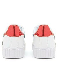 Sneaker bianchi con un accento rosso lucido sul tallone, dotati di una suola in gomma testurizzata e una parte superiore liscia. I dettagli includono cuciture lungo i lati.