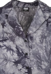 Koszula krótko rękawowa w szarym wzorze tie-dye, z kołnierzykiem z wycięciem, sześcioma czarnymi guzikami oraz miękkim, lekko teksturowanym materiałem.
