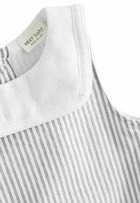 Prenda para bebé a rayas grises y blancas con cuello redondeado. Presenta un cierre de botón en la parte posterior. Está hecha de una suave tela texturizada.