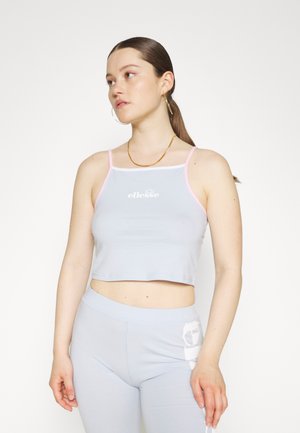 Ljusblå croppad linne med rosa kant, med en framlogotyp. Mjuk tyg med en figurnära design, kombinerad med matchande ljusblå leggings.