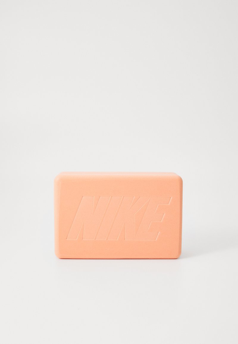 Peach-colored rectangular soap with a smooth texture and embossed "NIKE" logo on the front, featuring rounded edges.
