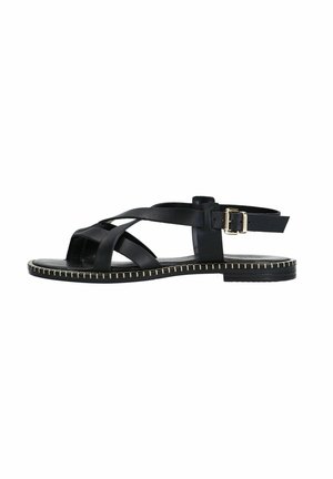 Zwarte leren sandaal met een open teenontwerp, kruislings gespen, een verstelbare sluiting en een platte zool met decoratieve stiksels.