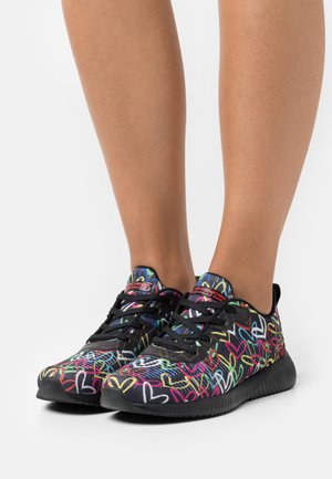 Schwarze Sportschuhe mit bunten Herzmustern, strukturiertem Stoff und schwarzen Gummisohlen. Standard-Lockverschluss für eine sichere Passform.