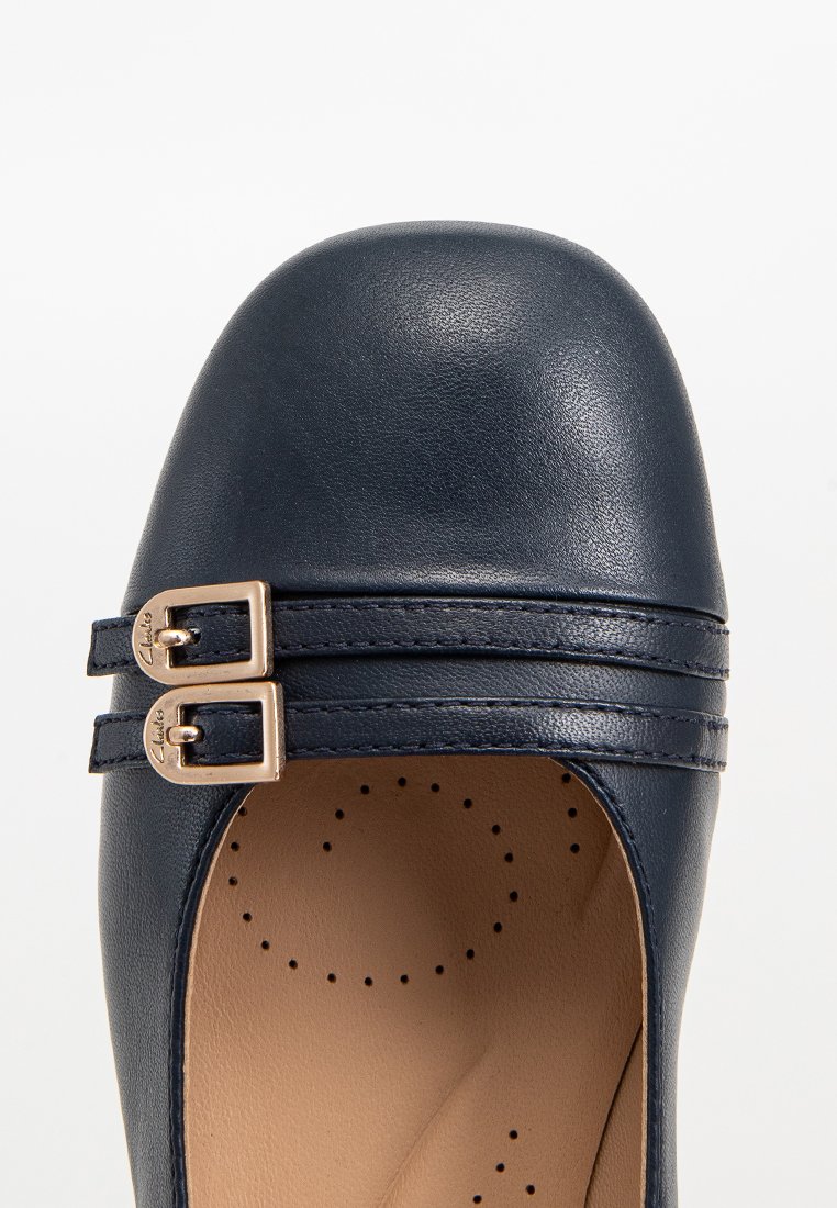 Dunkelblaue Lederschuhe mit runder Zehenpartie und zwei dekorativen Schnallen. Verfügt über perforierte Details im Inneren des Schuhs. Flache Sohle.