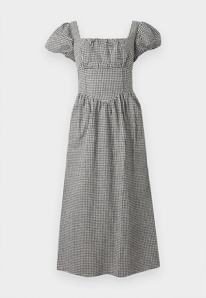 Robe midi en vichy noir et blanc avec manches courtes bouffantes et décolleté carré, corsage ajusté et jupe froncée.