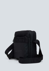 Sort stof crossbody tas med glat tekstur, lynlåslukning og justerbar rem med "JACK1T" logo i tonet tryk.