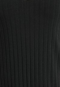 Tejido de punto acanalado negro con líneas verticales. Presenta un diseño de escote en v. Textura suave con un ligero brillo. Sin patrones ni acentos adicionales.