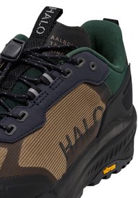 Wandel schoenen met een tan gekorrelde bovenkant, donkergroene accenten en een zwarte rubberen zool. Voorzien van een vetersysteem en logodetail aan de zijkant.
