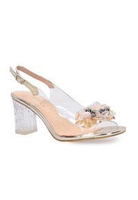 Transparenter Slingback-Absatz mit einem Kristall-Blockabsatz, dekorativen Edelstein-Akzenten, beigem Fußbett und metallic-goldenen Verzierungen. Offene Zehenpartie.