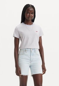 Striped T-shirt in light blue and white, short sleeves, round neckline, with a small red logo; paired with light blue denim shorts with frayed hem.