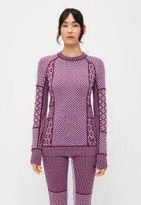 Lila sportos szett, hosszú ujjú felsővel, vegyes mintákkal és bordázott részletekkel, hozzáillő, szűk, csíkos leggings-sel.