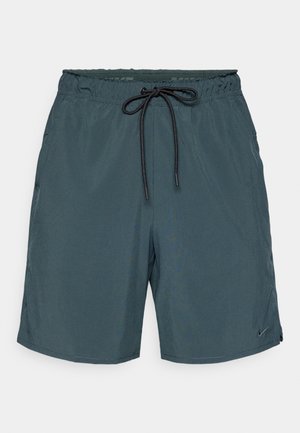 Pantaloni da bagno da uomo in tessuto verde scuro con vita elastica, cordino regolabile e tasche laterali. Logo Nike sull'orlo inferiore.
