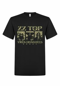 Černé bavlněné tričko s potiskem na přední straně, na kterém jsou zobrazeny tři vousaté postavy, text „ZZ TOP“ nahoře a „TRES HOMBRES“ dole v opotřebovaném žlutém písmu.