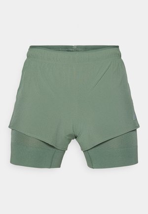Light green athletic shorts with a double-layer design; top layer is perforated, while the inner layer is fitted with a ribbed texture.
