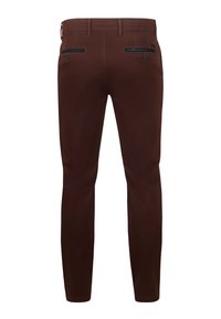 Braune Hosen aus einem glatten Stoff, mit einer schlanken Passform, zwei Gesäßtaschen mit Reißverschlüssen und Gürtelschlaufen in der Taille.