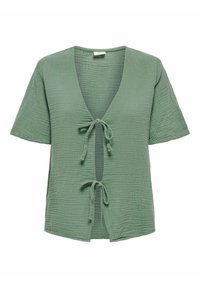 Top avvolgente verde a maniche corte realizzato in un tessuto testurizzato con scollatura a V profonda e chiusure a lacci nella parte anteriore. Materiale leggero e traspirante.
