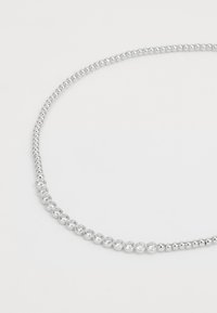 Collier en argent avec des perles rondes et des accents en cristal transparent alternés, présentant un design circulaire uniformément et une texture lisse.