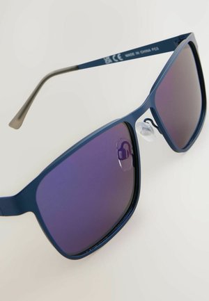 Blå solglasögon med en slank, kantig design och lila gradientlinser. Inkluderar klara näskuddar och en texturerad skalmar för bättre grepp.