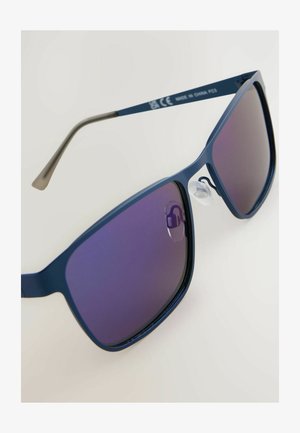 Gafas de sol azules con un diseño elegante y angular y lentes de gradiente púrpura. Incluye almohadillas nasales transparentes y una patilla texturizada para un mejor agarre.