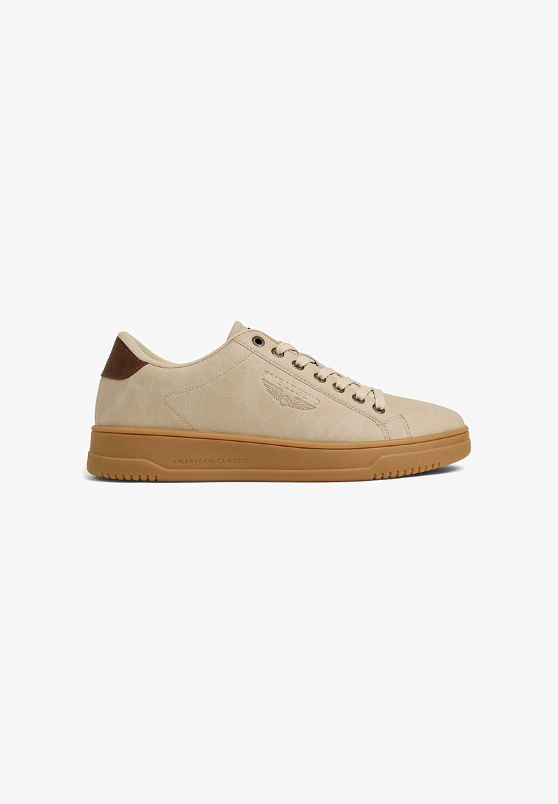 Baskets basses beige avec semelle en gomme, fermeture lacets à l'avant, patch marron au talon et logo embossé sur le côté indiquant "American Classic."