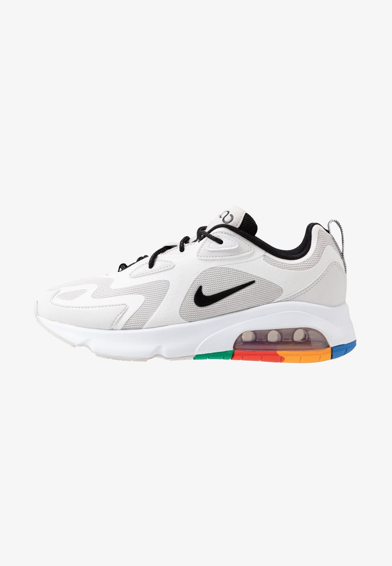 Chaussure de sport blanche avec une maille texturée et un matériau synthétique. Comprend un logo Nike noir, un coussin d'air coloré et des accents de semelle multicolores.